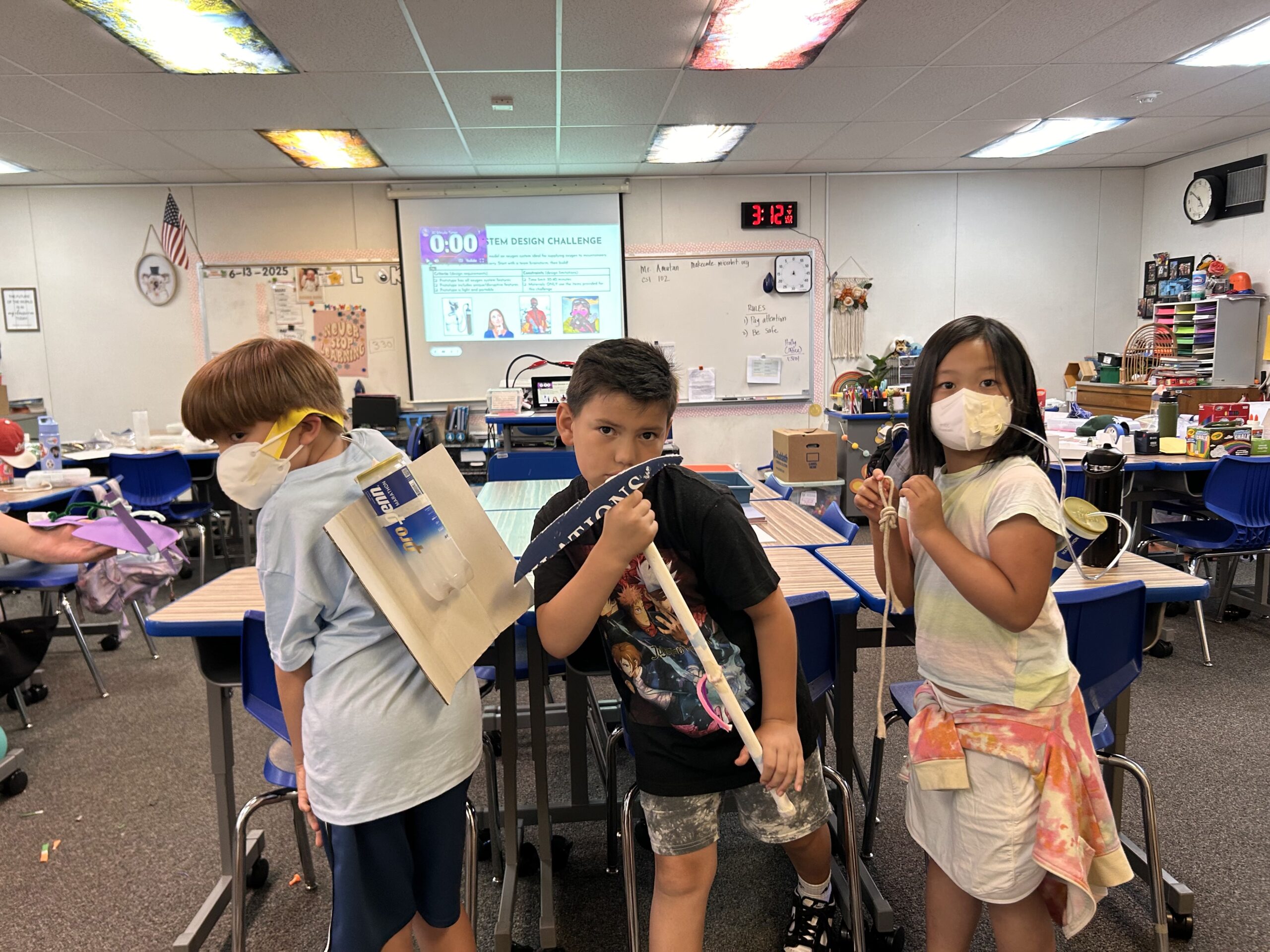 Three proud campers show off their creative ice axe prototypes, designed to keep mountaineers safe during Innovation Lab week.