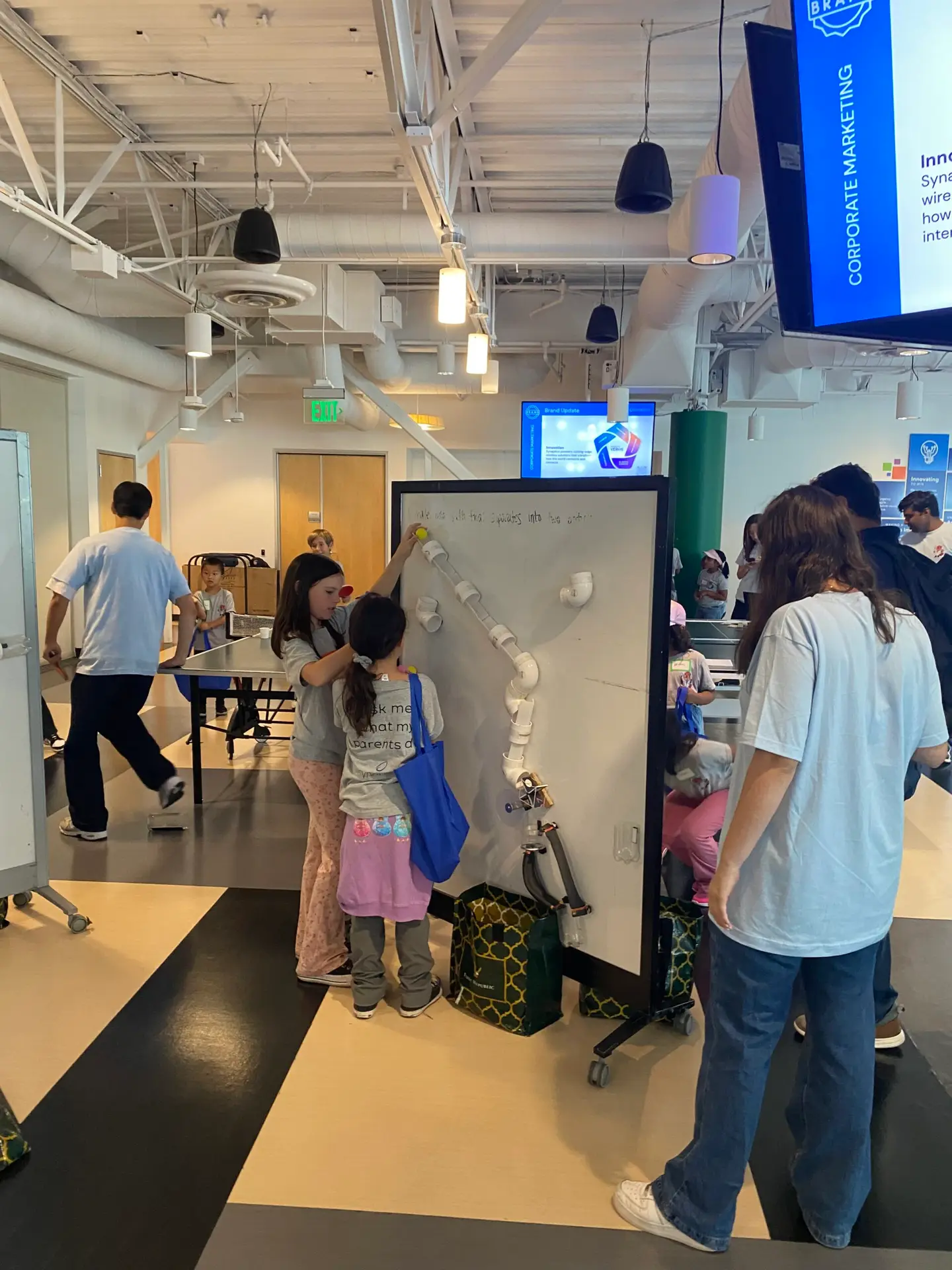 Teamwork in action! Kids collaborate to solve a hands-on RAFT STEAM Design Challenge during Bring Your Kids to Work Day.