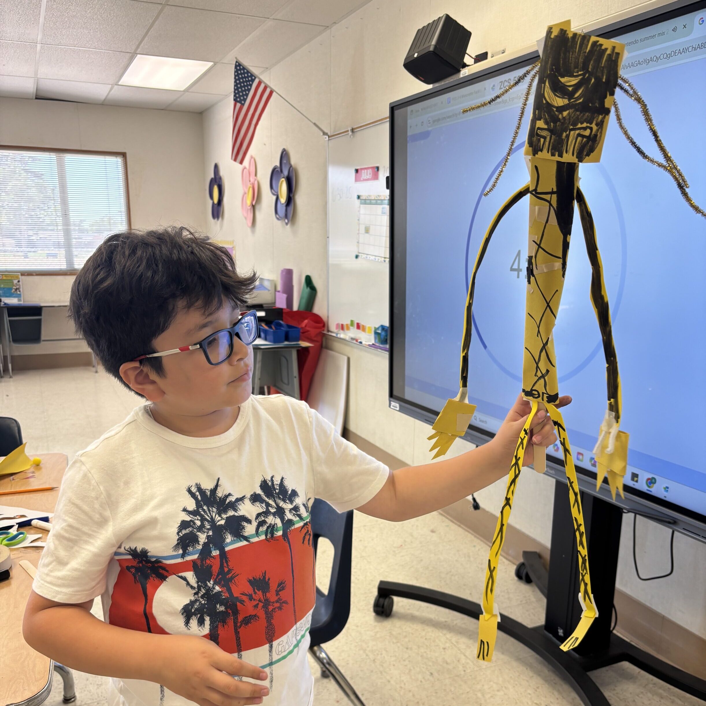 A camper proudly showcases his handmade puppet, ready to take the stage for Puppet Theater week!